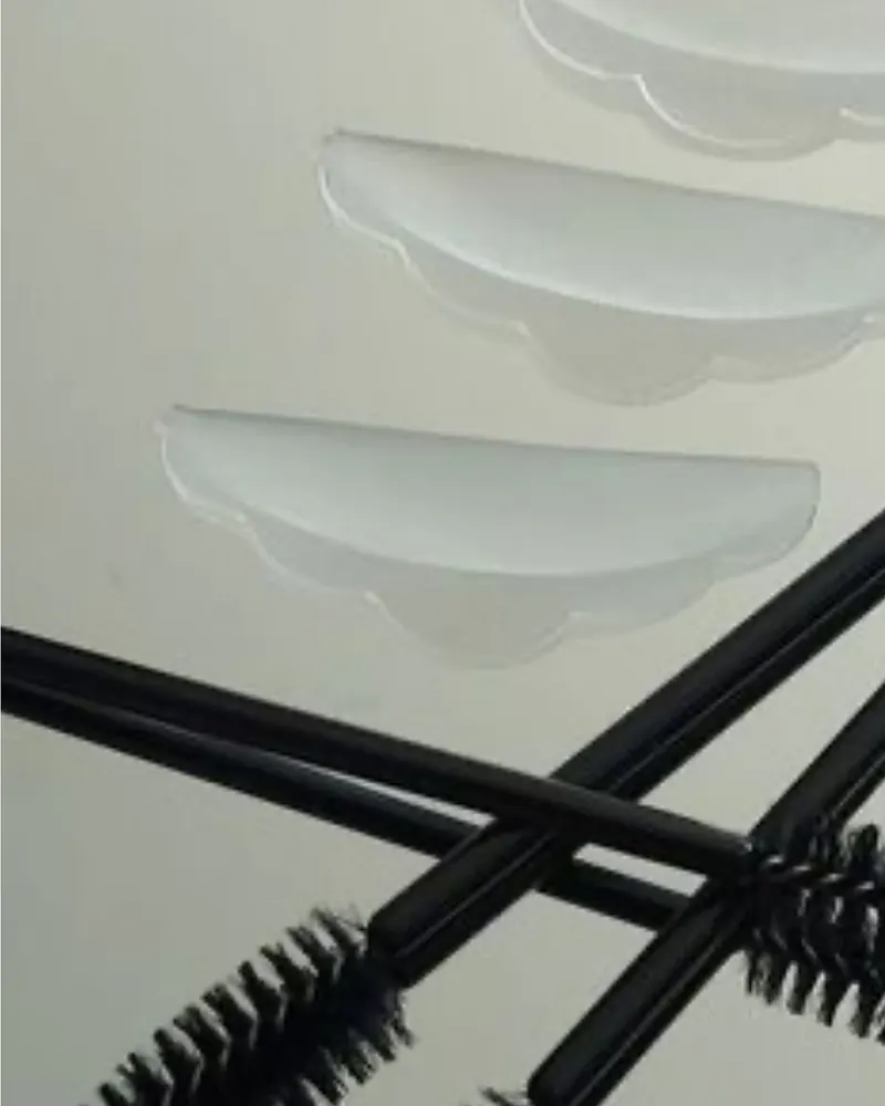Moldes de silicone e escovas usados no lash lifting, sobre superfície clara