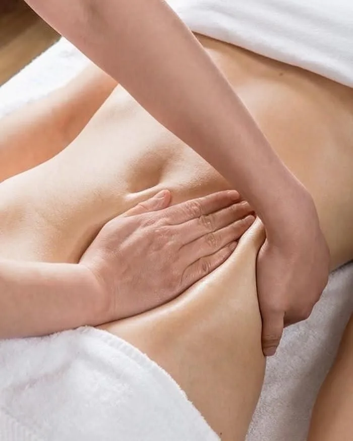 mulher recebendo massagem na região do abdome
